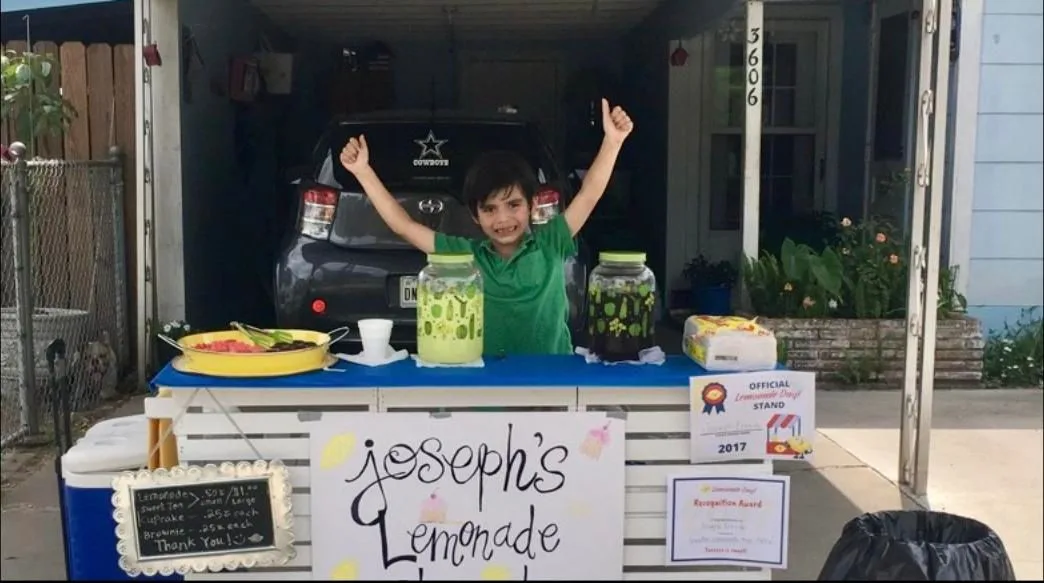 Kids laughing behind their lemonade stand