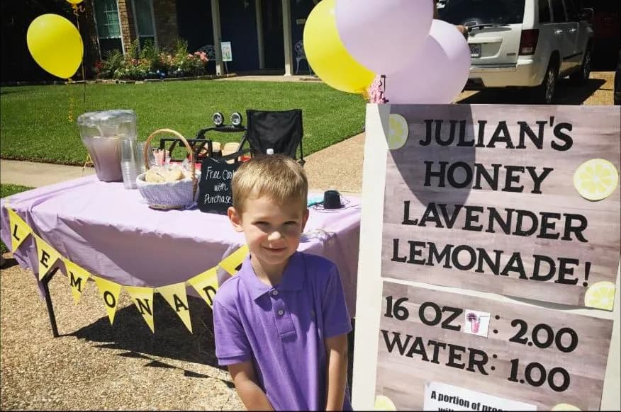 A kid and a mentor planning a lemonade business at the kitchen table
