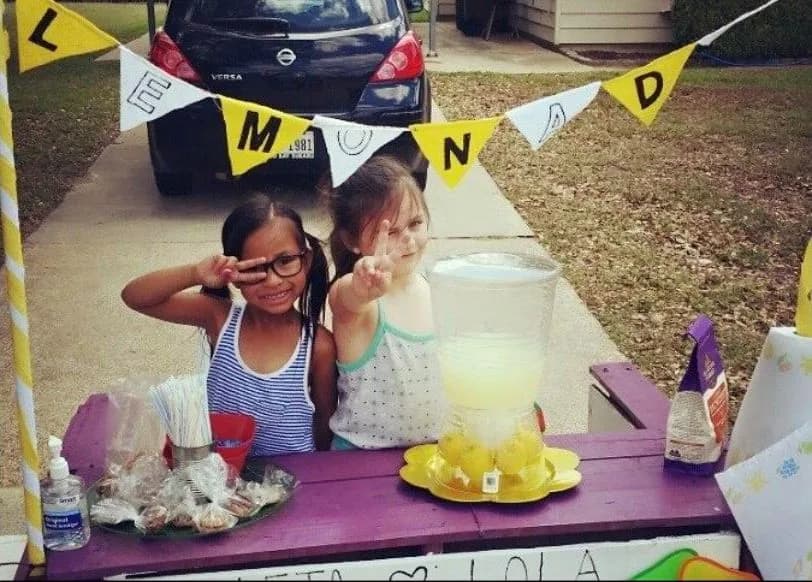 A kid pouring lemonade for a customer