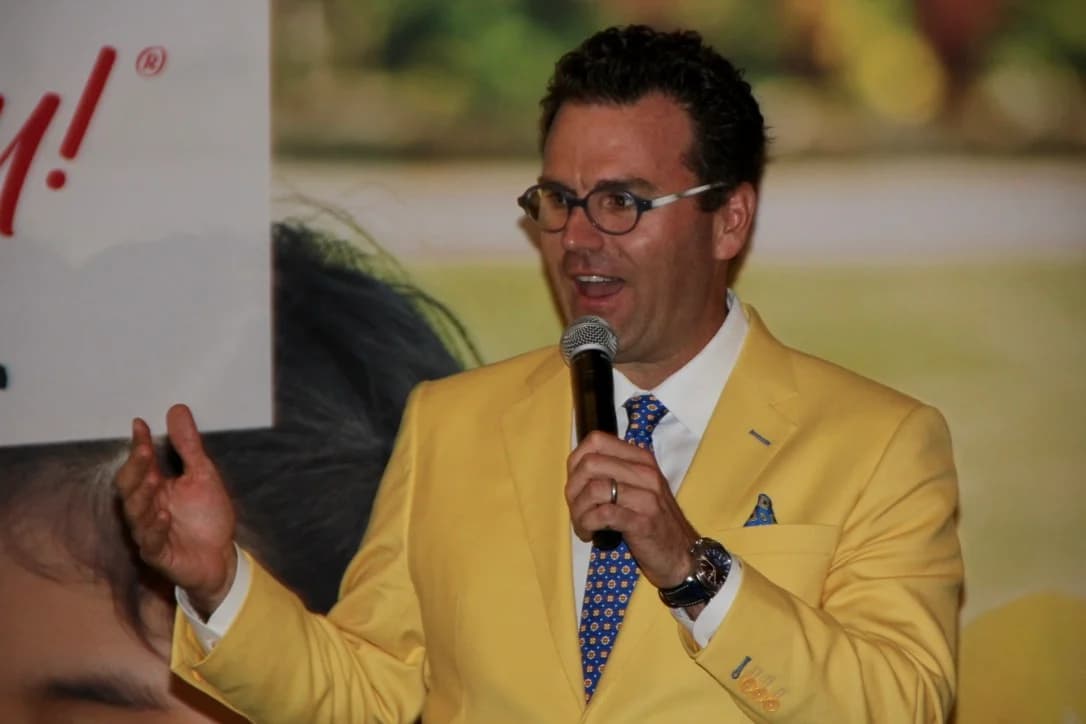 Charlie Hamilton, Lemonade Day National Board member, speaking on stage in a yellow jacket