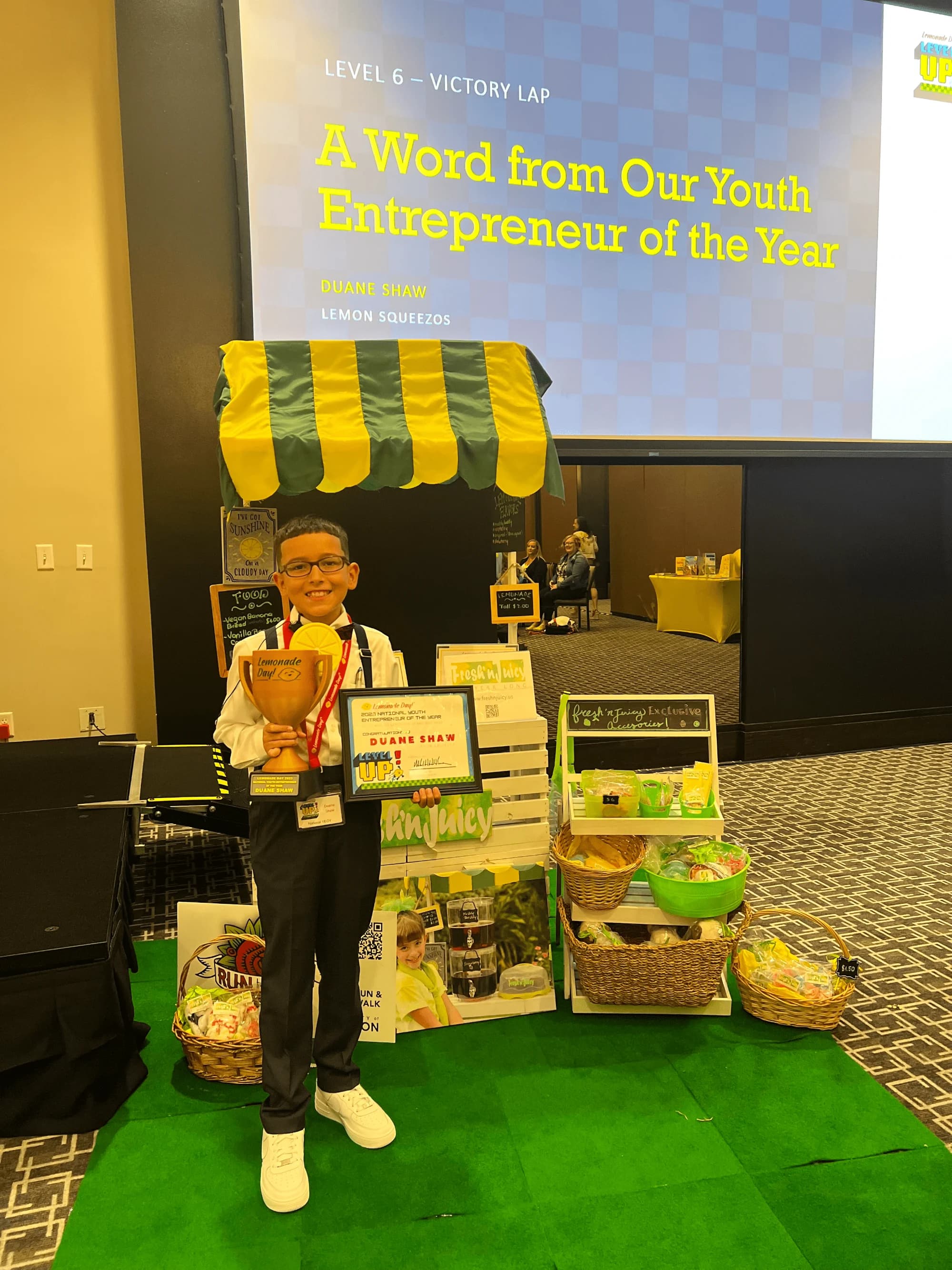 Duane Shaw beside his Lemon Squeezos stand on stage