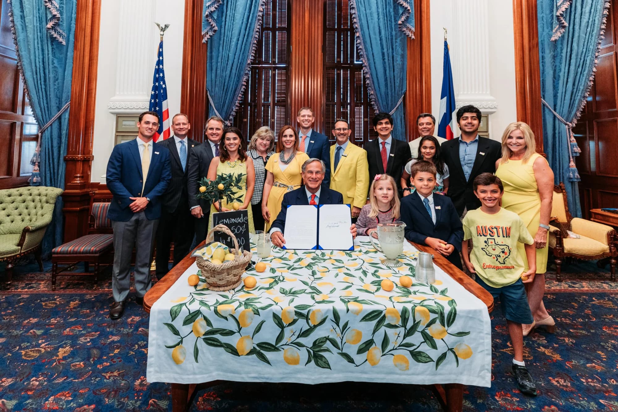 Kids in yellow with officials at the Texas Capitol