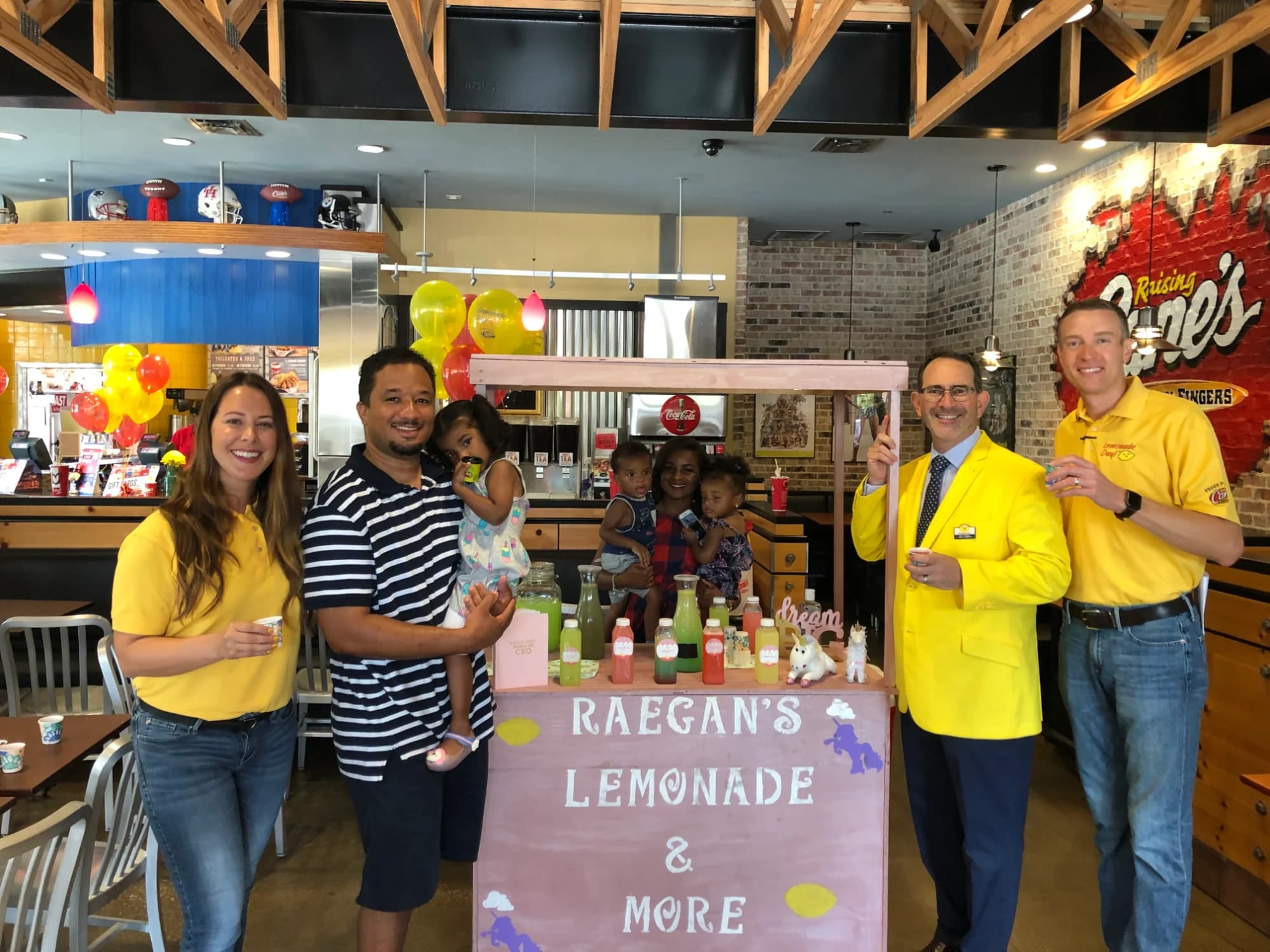 A kid at Raegan's Lemonade & More stand inside a Raising Cane's